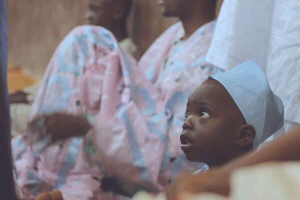 Child Looking Up Among Adult Celebrants